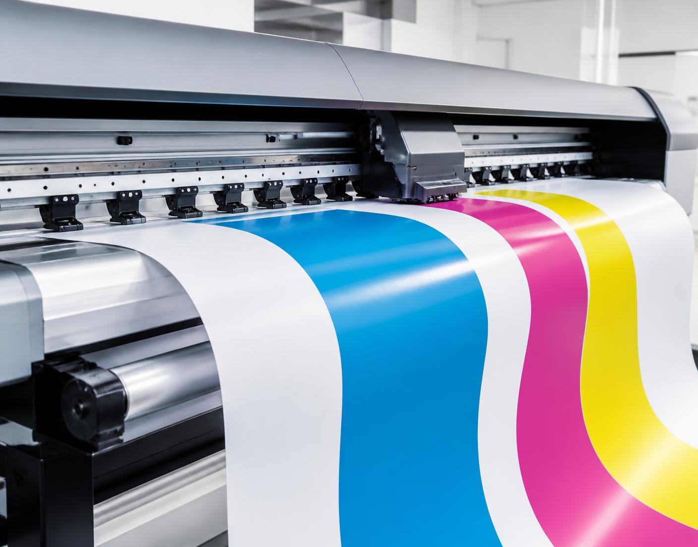 Wide-format printer laying down cyan, magenta and yellow ink on white vinyl